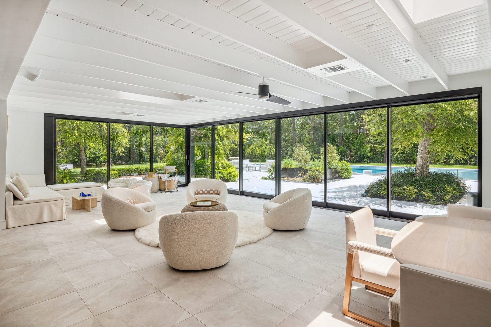 The solarium at Shadow Sanctuary with sliding glass walls opening onto the wooded grounds.